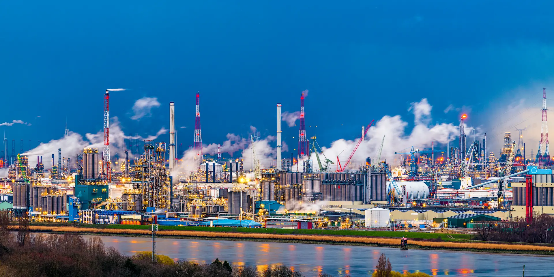 Modernizovano industrijsko postrojenje sa automatskim kontrolnim sistemima, u večernjim uslovima rada.